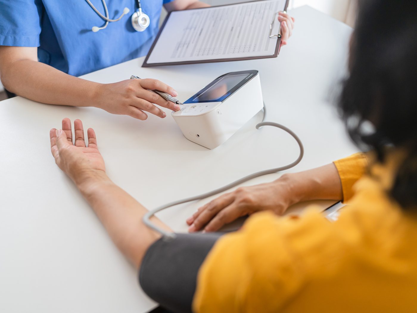 A nurse taking a blood pressure reading at a table